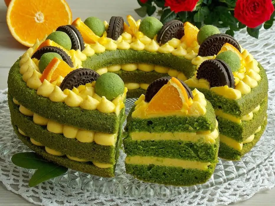 Tort vesel colorat, vedeta pe masa de sarbatoare, cu crema de portocale, budinca de vanilie, ciocolată albă si biscuiți
